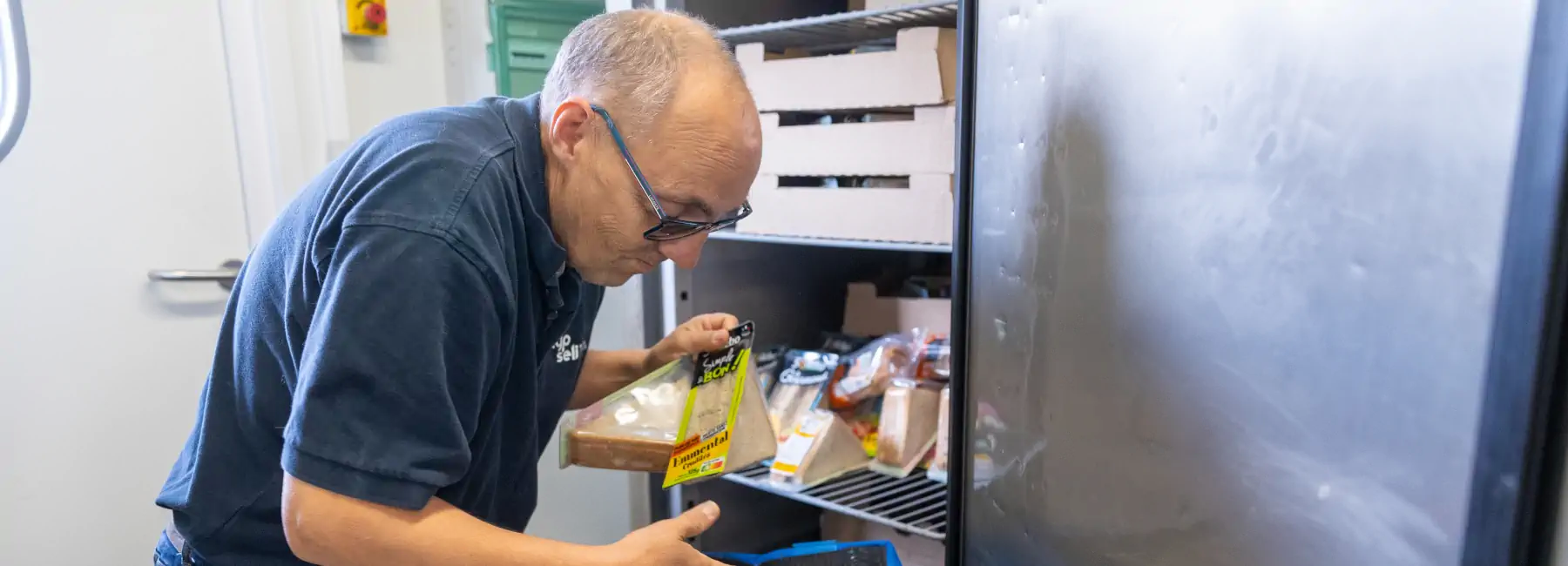 Homme en train de remplir un frigo